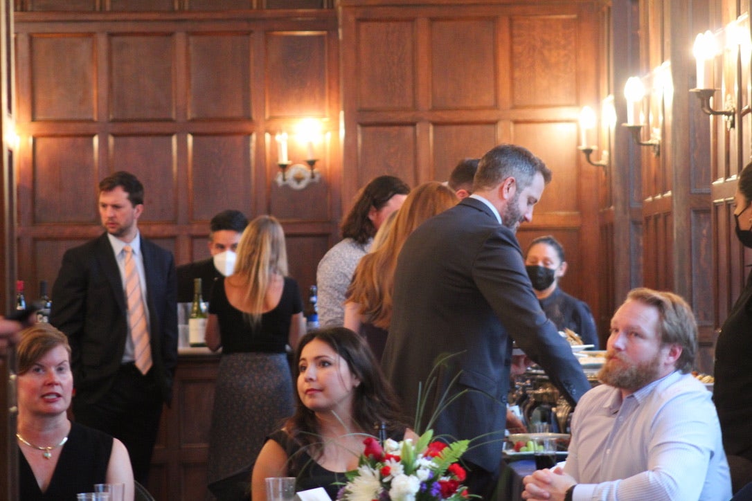 people sitting and standing around tables