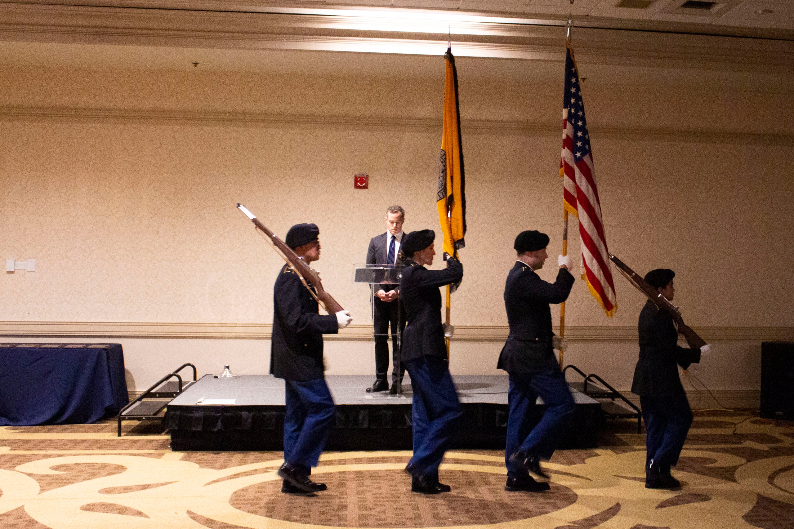Army ROTC color guard walking in front of stage