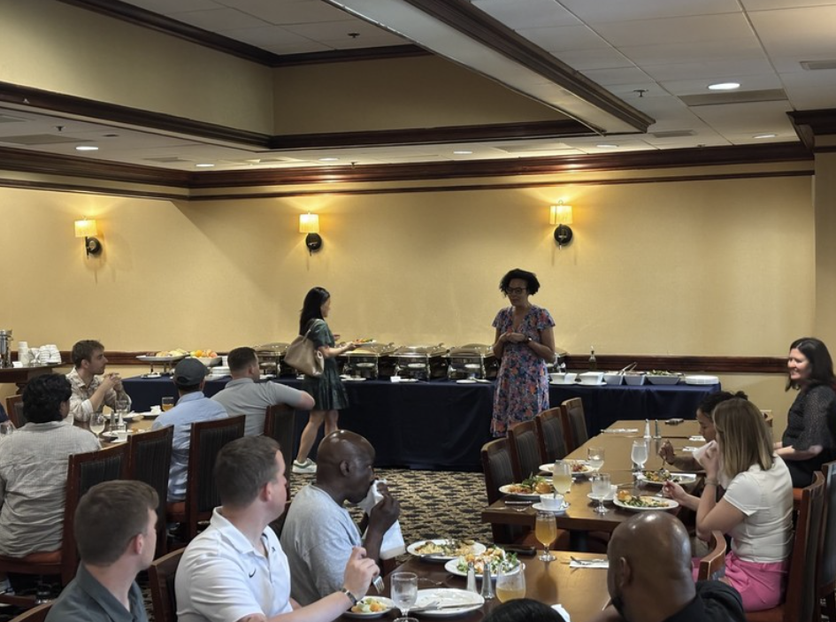 A presenter speaking at a group dinner