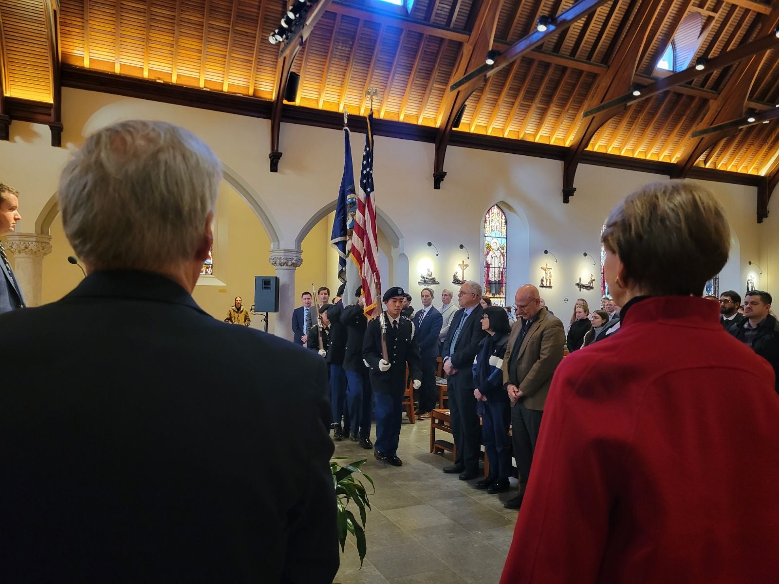 Color guard in the background of keynote speaker and interim president Groves standing