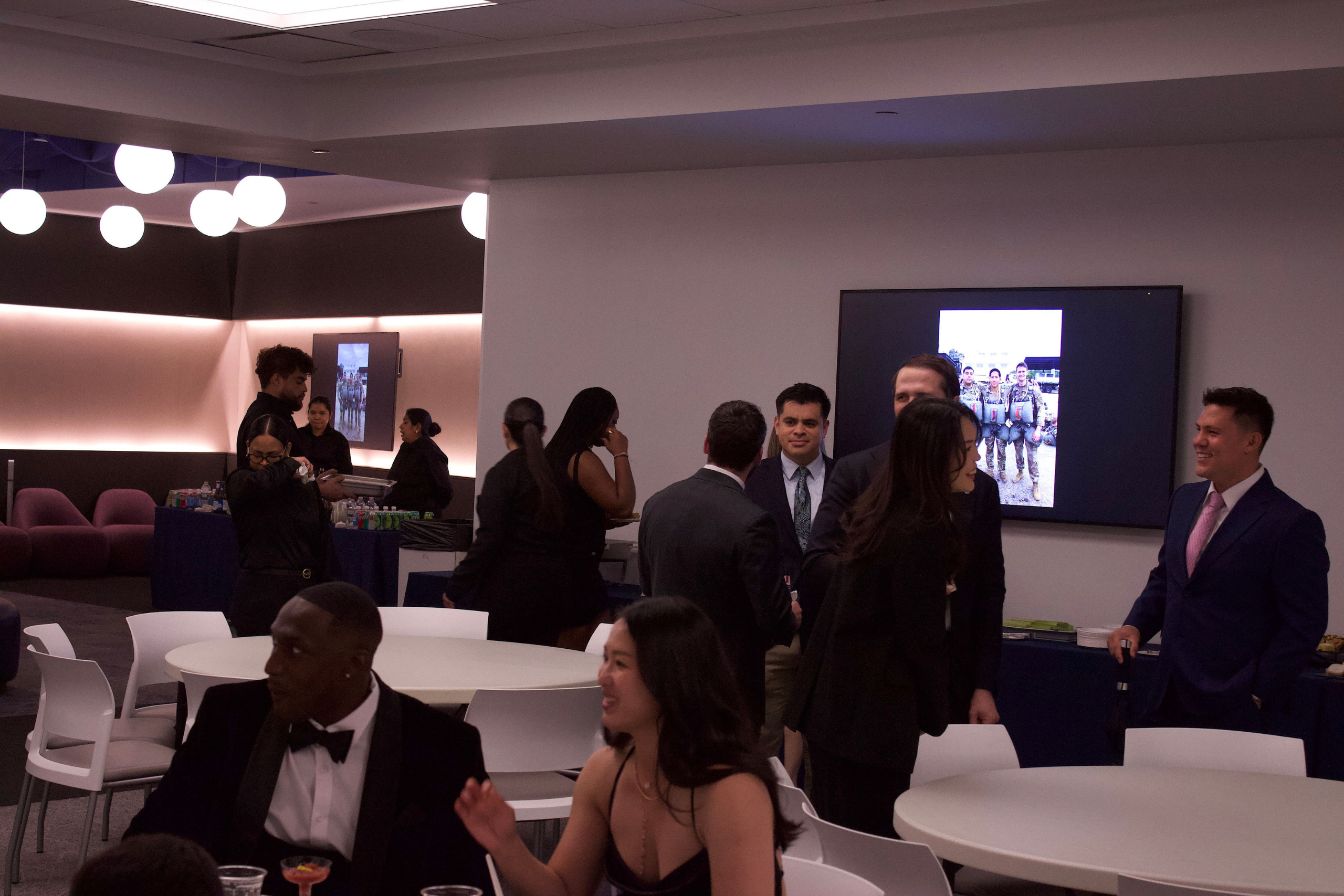 People mingling around white round tables