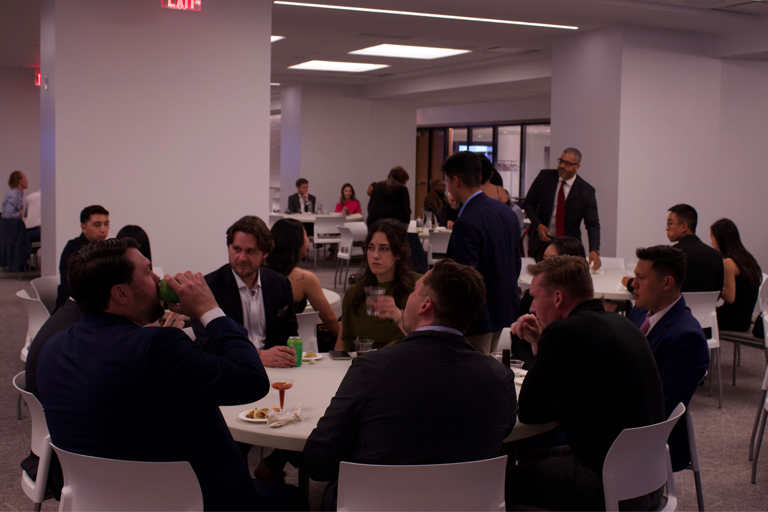 People sitting around white tables talking