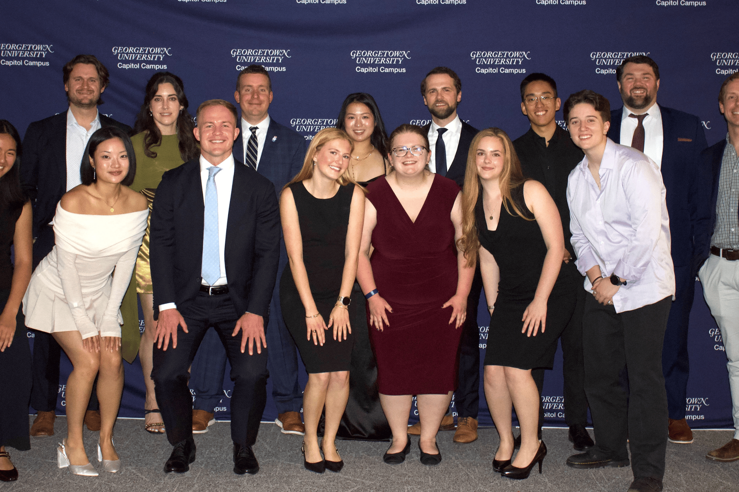 MAVRC employees posing for a group photo in front of a backdrop with repeating Georgetown logos