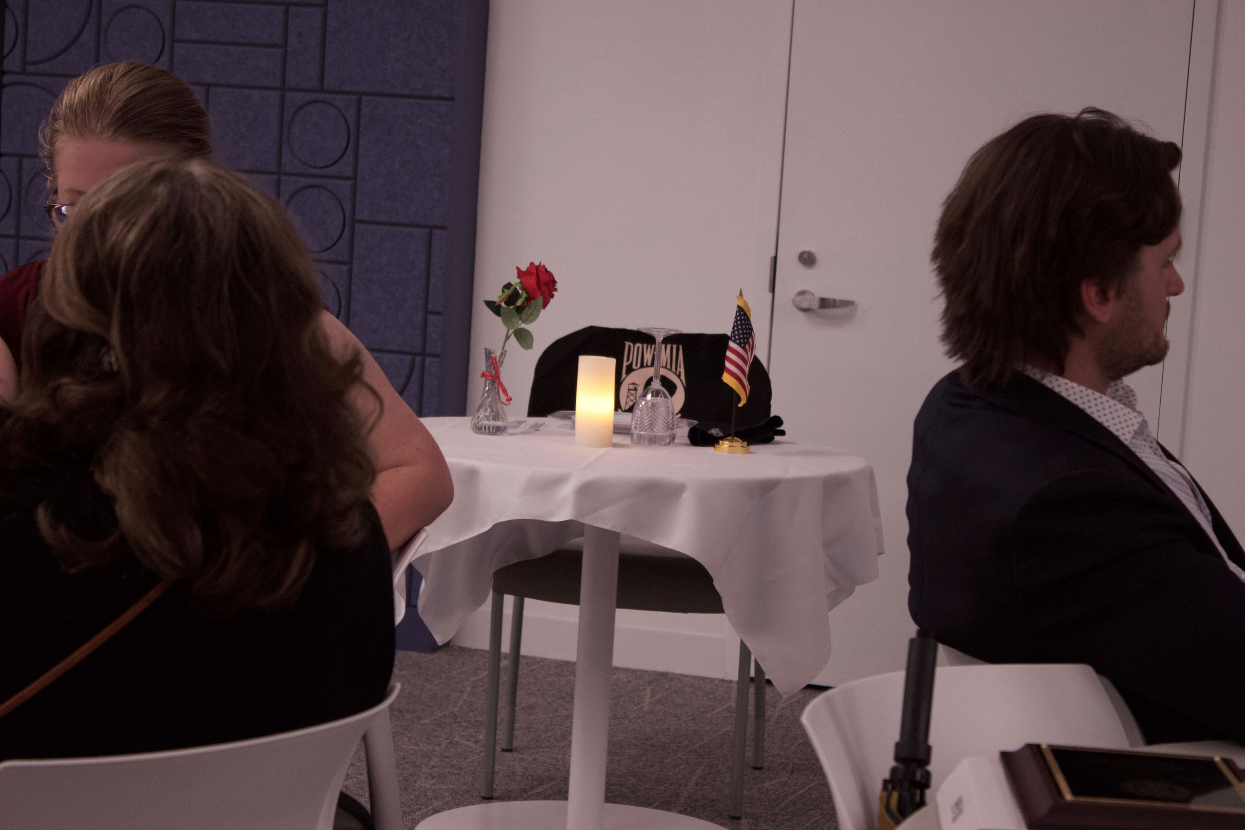 Far-off POW/MIA table between people sitting in chairs