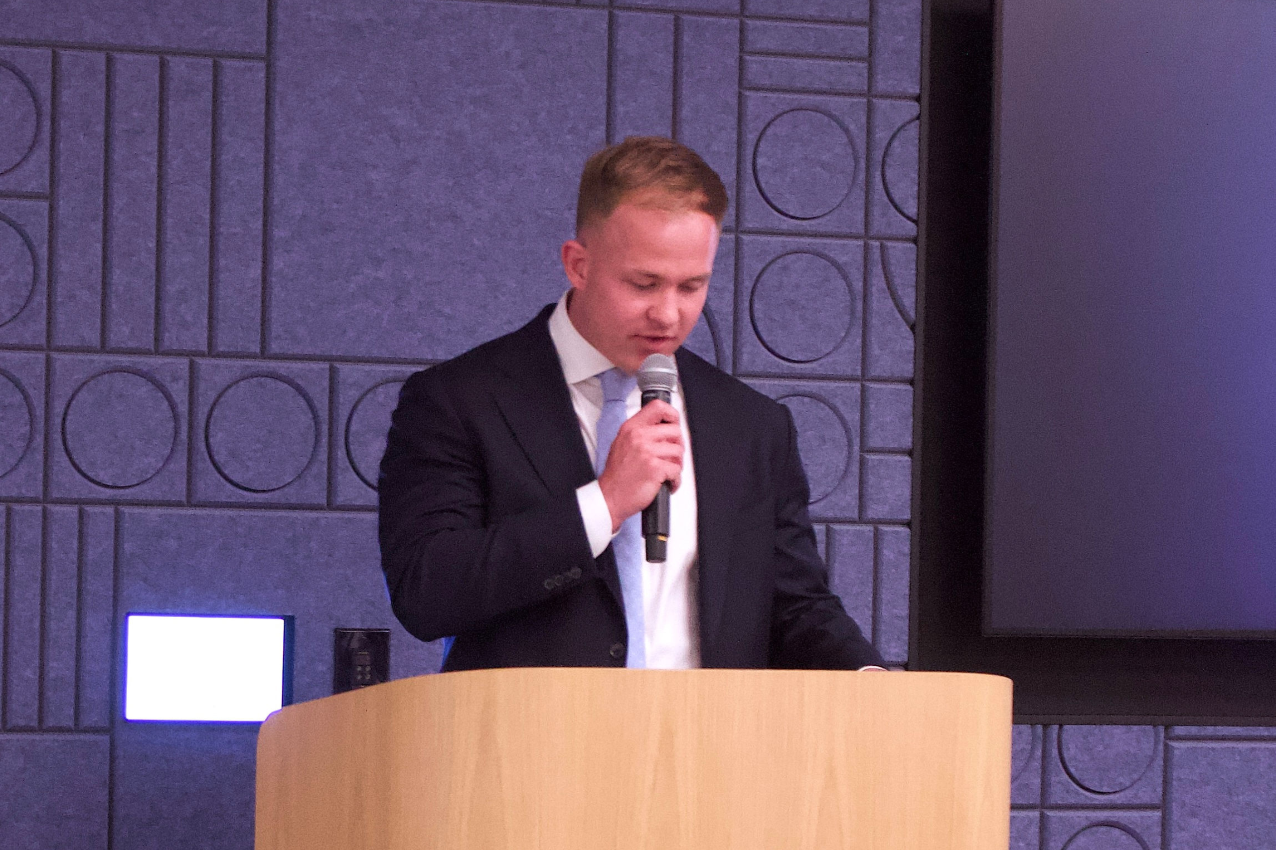 A man speaking into a microphone at a podium