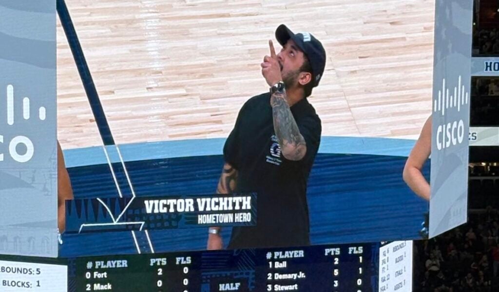 A man on a jumbo tron at a basketball game