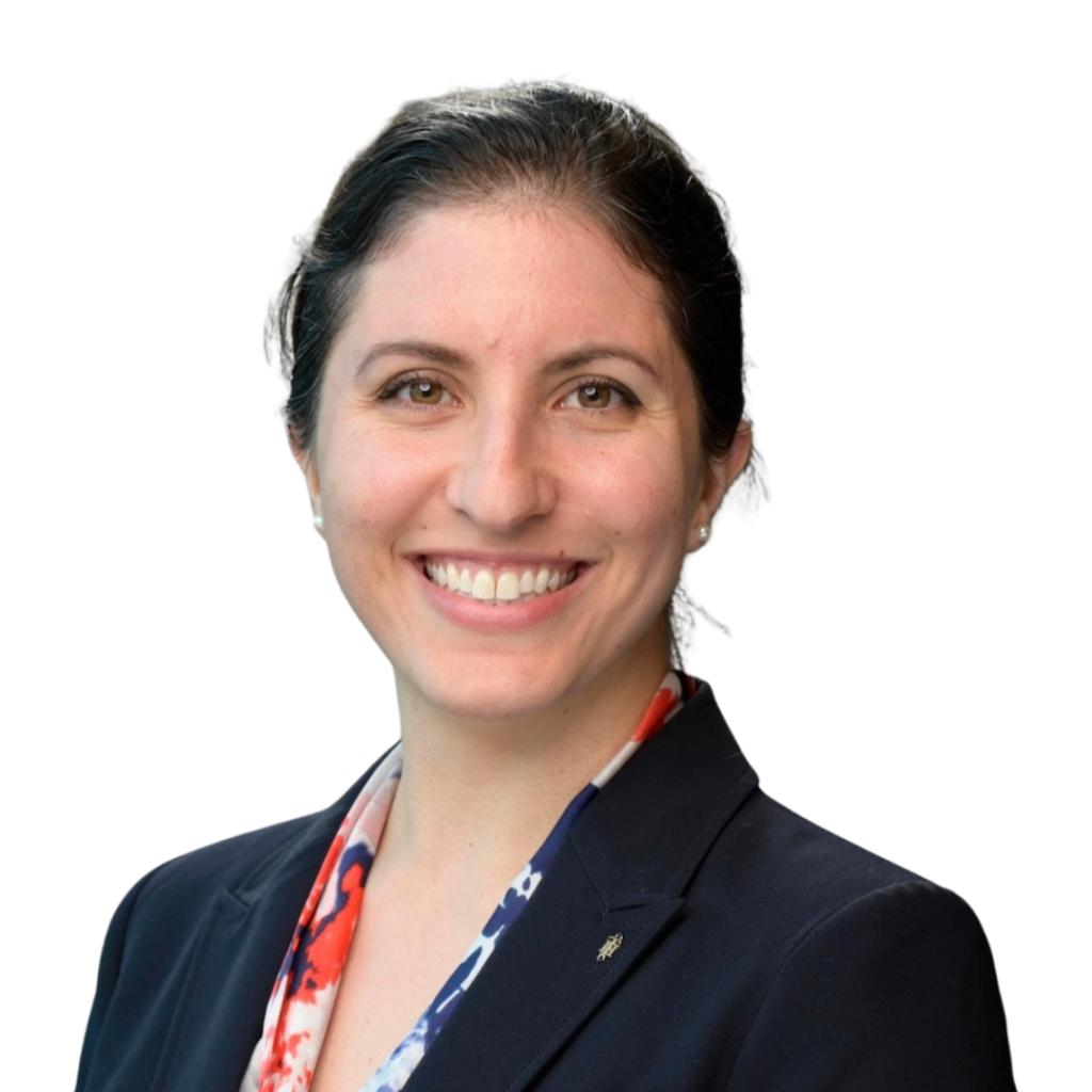 A Hispanic woman with dark brown hair pinned up wearing a black blazer and colorful printed undershirt