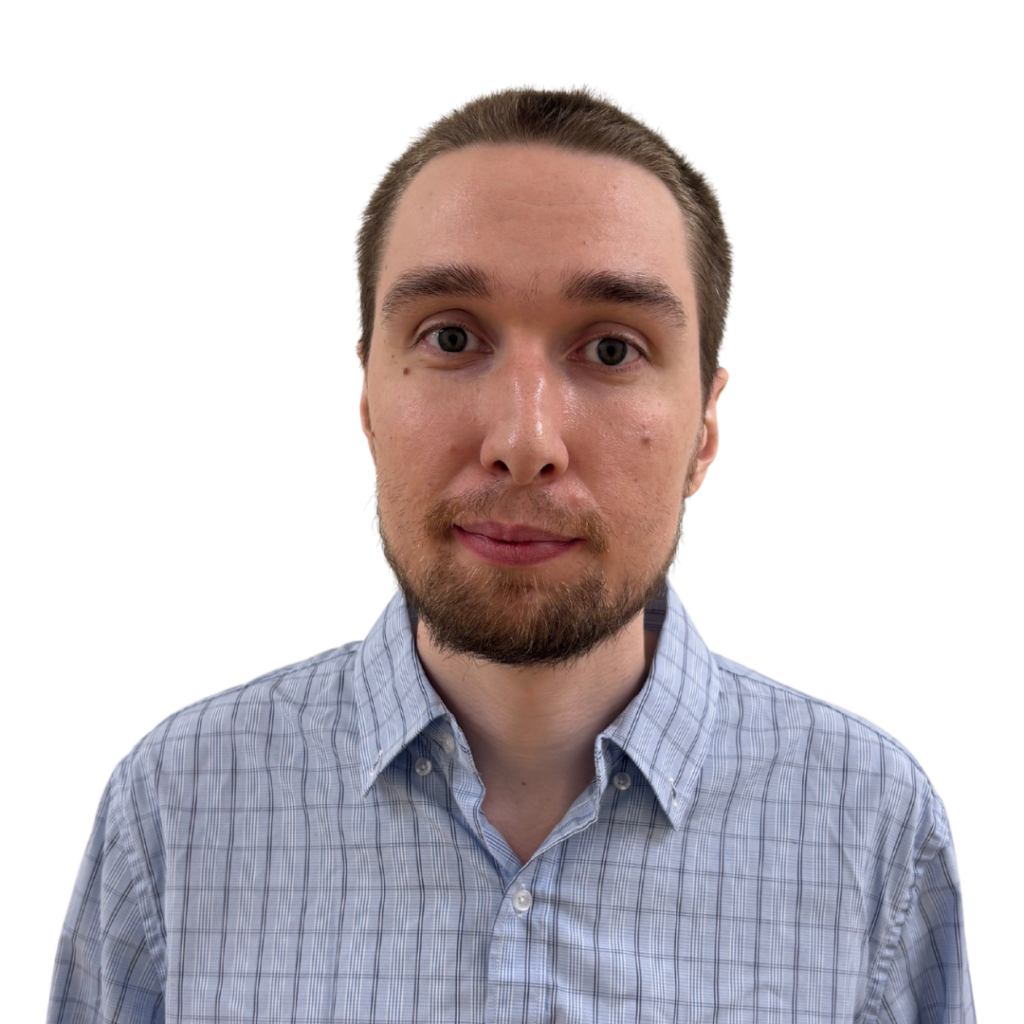A white man with short cropped brown hair wearing a light blue checkered button down