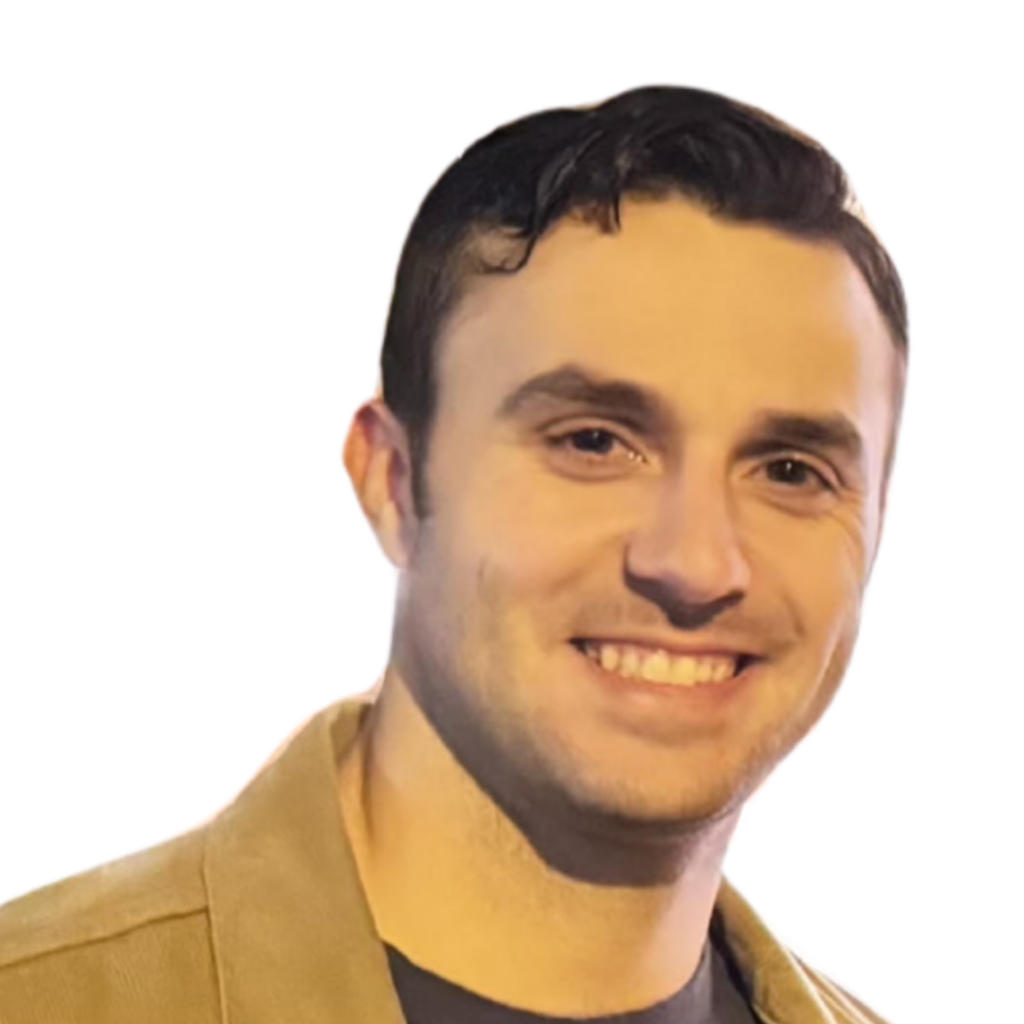 White man with short black hair wearing a tan jacket