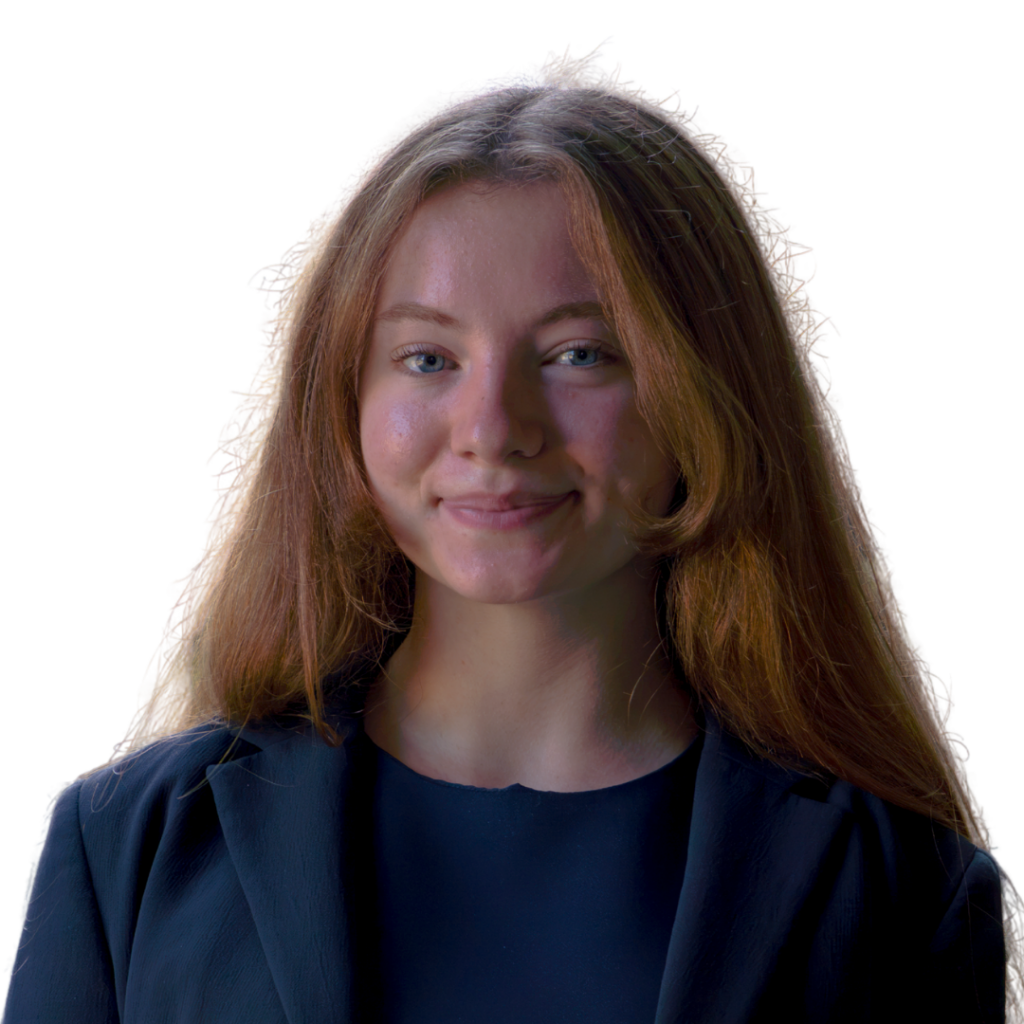 A white woman with long red hair wearing a dark blue blazer and shirt